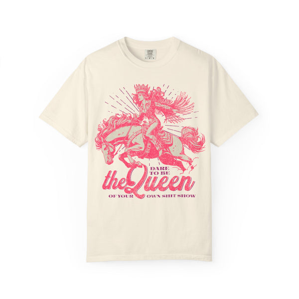 Black oversized t-shirt featuring a bold pink graphic of a cowgirl wearing a crown and fringe, riding a horse. Text reads “Dare to be the Queen of your own sh*t show.” Western-inspired, empowering design with a humorous twist.