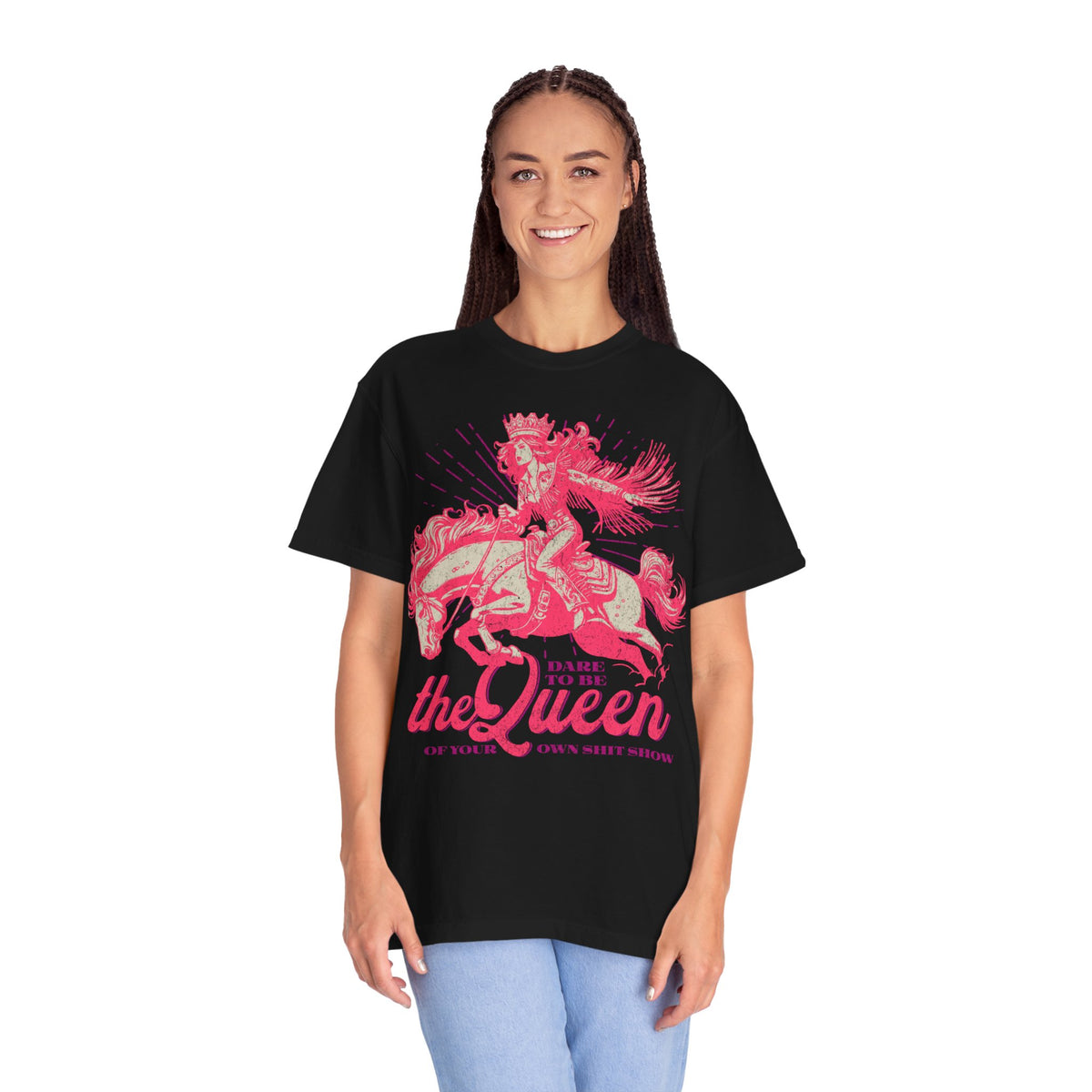 Black oversized t-shirt featuring a bold pink graphic of a cowgirl wearing a crown and fringe, riding a horse. Text reads “Dare to be the Queen of your own sh*t show.” Western-inspired, empowering design with a humorous twist.

