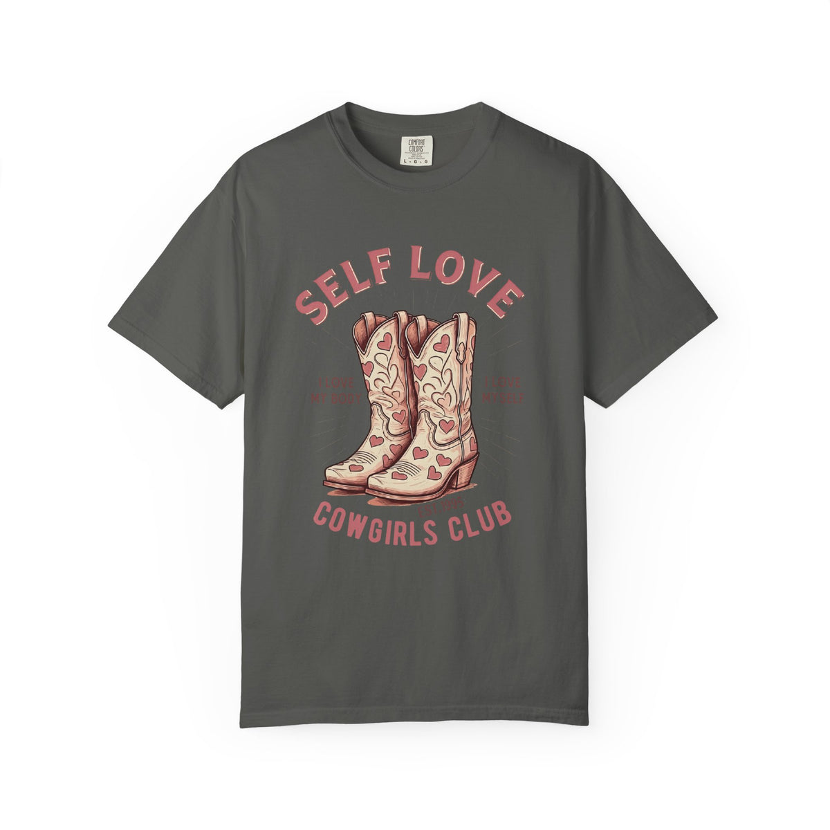 Cream oversized vintage-style t-shirt featuring a graphic of cowgirl boots with pink hearts and the phrase “Self Love Cowgirl Club – I love my body, I love myself.” Western-inspired design with a bold, empowering message.
