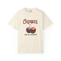 Cream oversized vintage-style t-shirt featuring a bold graphic of two red cherries and the text “My Cherries Are My Business.” A flirty and confident design perfect for making a bold statement.
