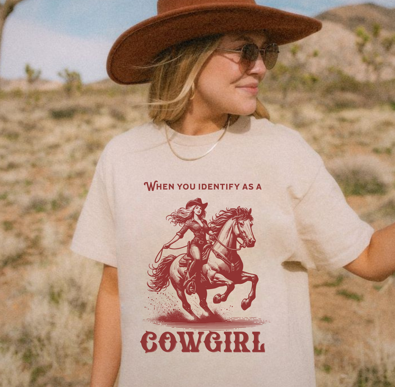 Model wearing an oversized 'When You Identify as a Cowgirl' T-Shirt with a western-inspired design. Soft, vintage-washed cotton, perfect for country-core and cowgirl aesthetic lovers.