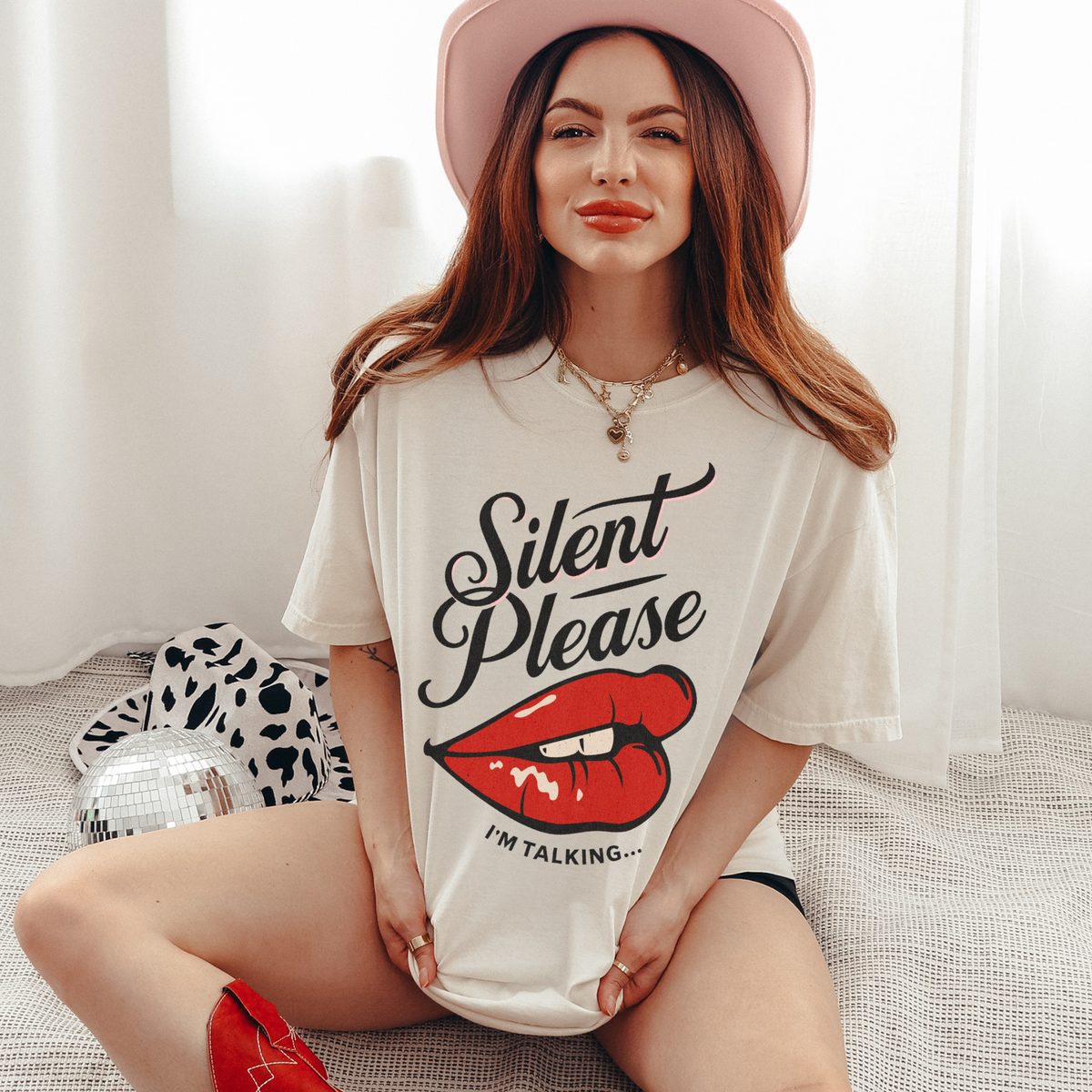 Cream oversized vintage-style t-shirt featuring a bold graphic of glossy red lips and the text “Silent Please I'm Talking...” A sassy and empowering design perfect for confident, bold style.

